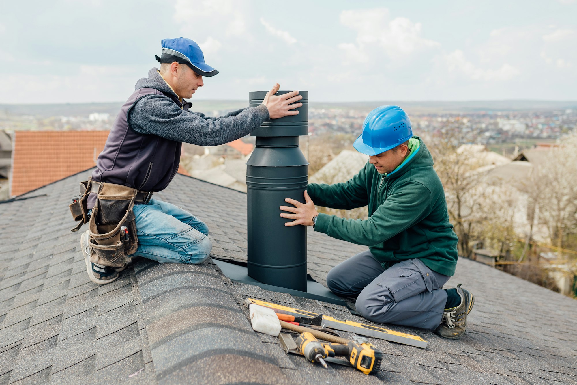 two Professional workmen's standing roof top and measuring chimney Measuring Chimney